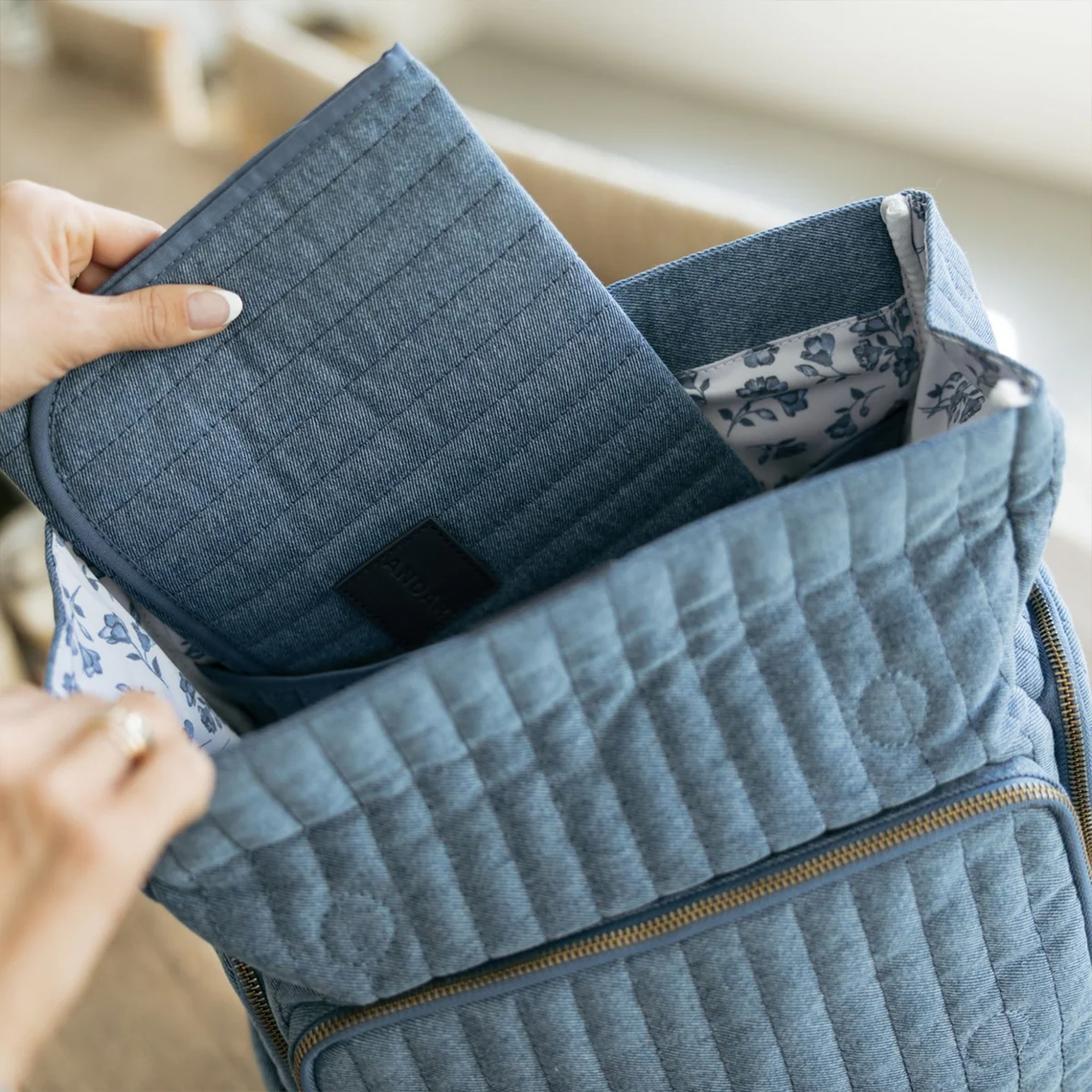 Soft Washed Light Blue Vertical Quilted Fold Flap Backpack With Floral Pattern Inner Lining, Multi Zippered Side Storage Compartments And Wide Quilted Rear Shoulder Straps