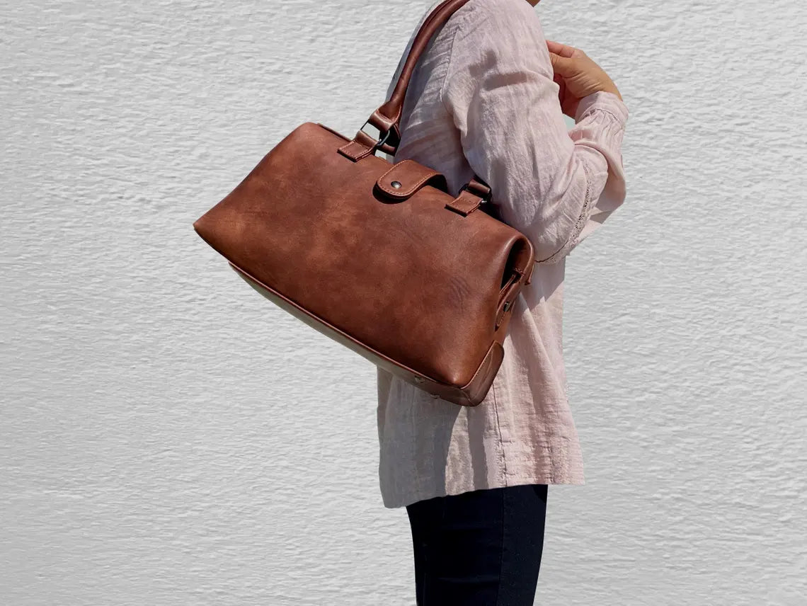 Warm Faded Tan Structured Vintage Frame Satchel With Dual Curved Top Hand Grips, Central Snap Tab Closure And Rear Horizontal Zipper Slip Pocket