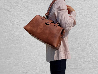 Warm Faded Tan Structured Vintage Frame Satchel With Dual Curved Top Hand Grips, Central Snap Tab Closure And Rear Horizontal Zipper Slip Pocket