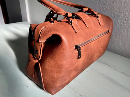 Warm Faded Tan Structured Vintage Frame Satchel With Dual Curved Top Hand Grips, Central Snap Tab Closure And Rear Horizontal Zipper Slip Pocket