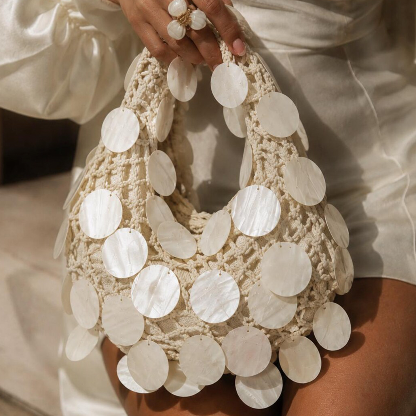 Soft Ivory Open Crochet Curved Hobo Handbag With Scattered Glossy Circular Shell Disc Embellishments And Integrated Loop Carry Handle