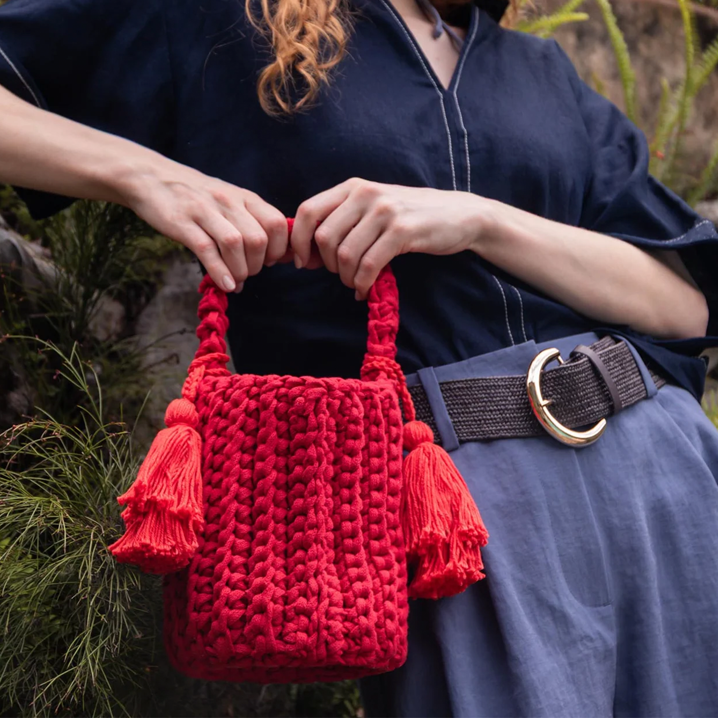 Multi-Tone Chunky Vertical Knit Compact Bucket Handbag With Braided Loop Handle And Dual Layer Fabric Tassel Side Embellishments Handbag