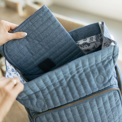 Soft Washed Light Blue Vertical Quilted Fold Flap Backpack With Floral Pattern Inner Lining, Multi Zippered Side Storage Compartments And Wide Quilted Rear Shoulder Straps